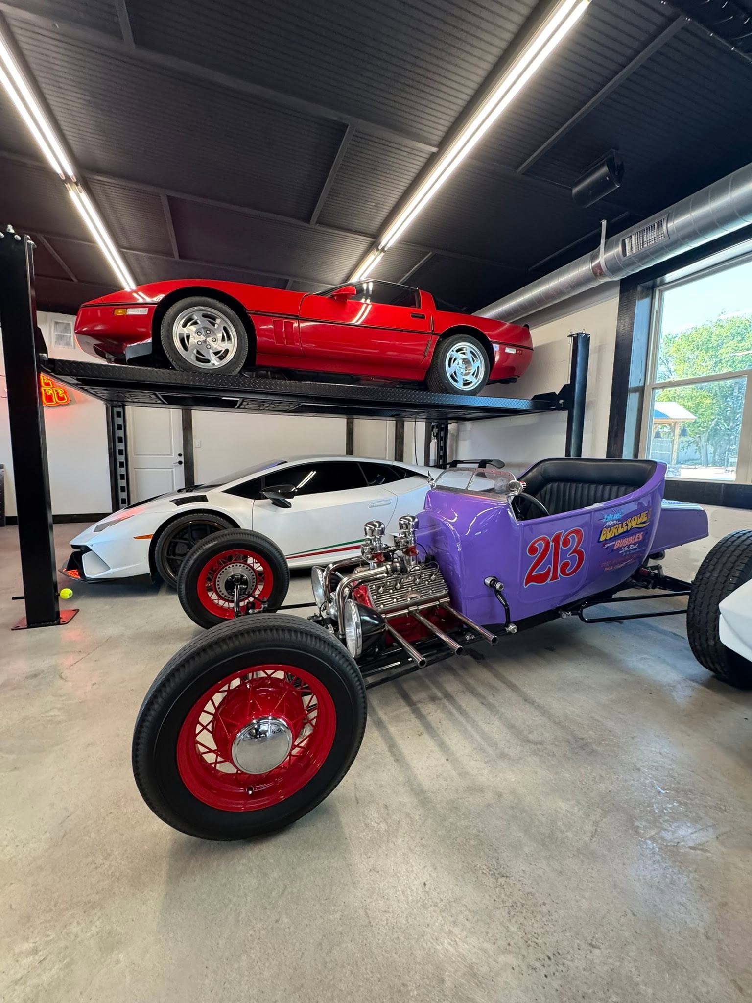 Hot rods and a red collector car displayed inside GMTV Garage