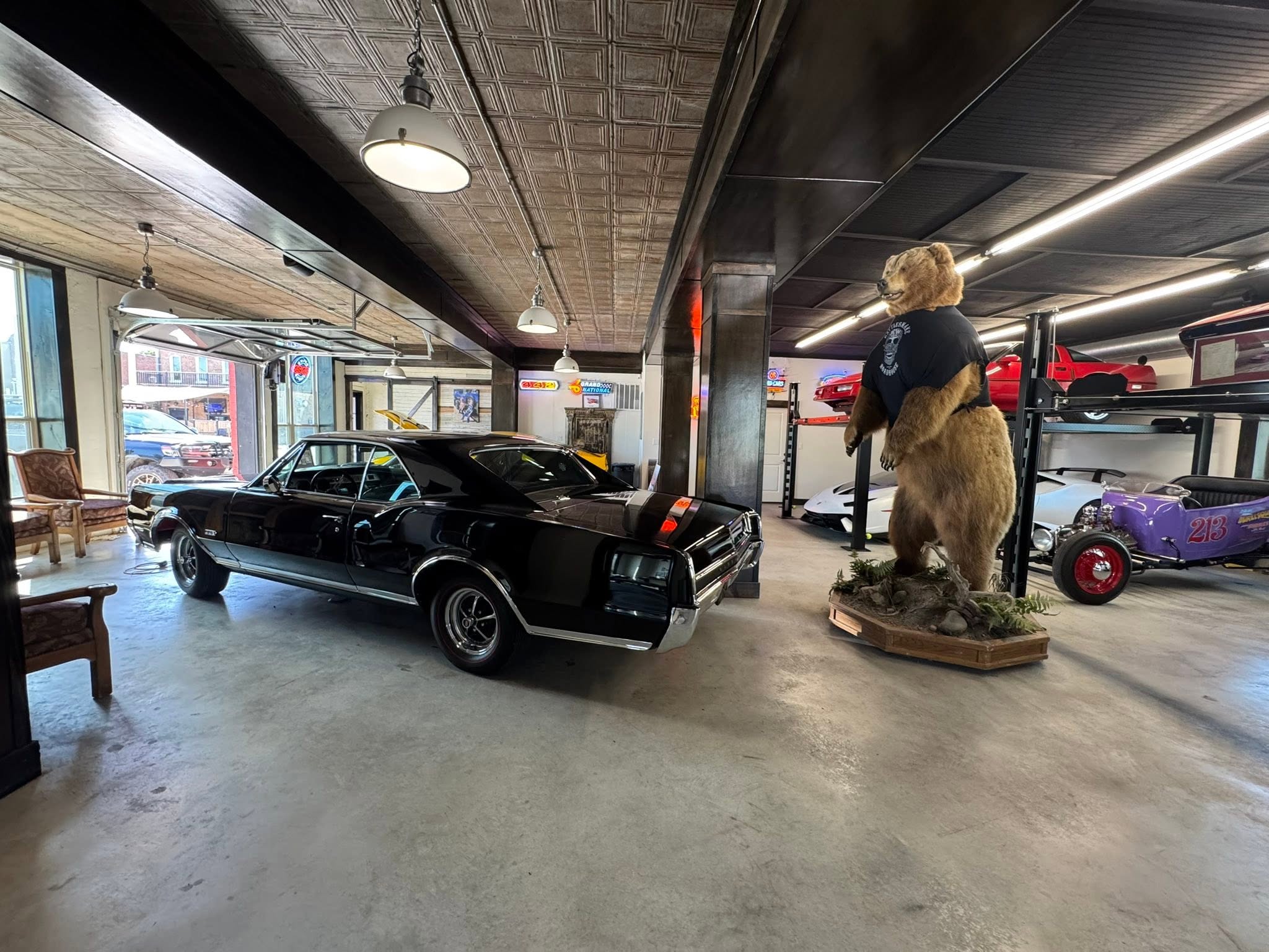 Pair of black collector cars beneath the timber ceiling at GMTV Garage
