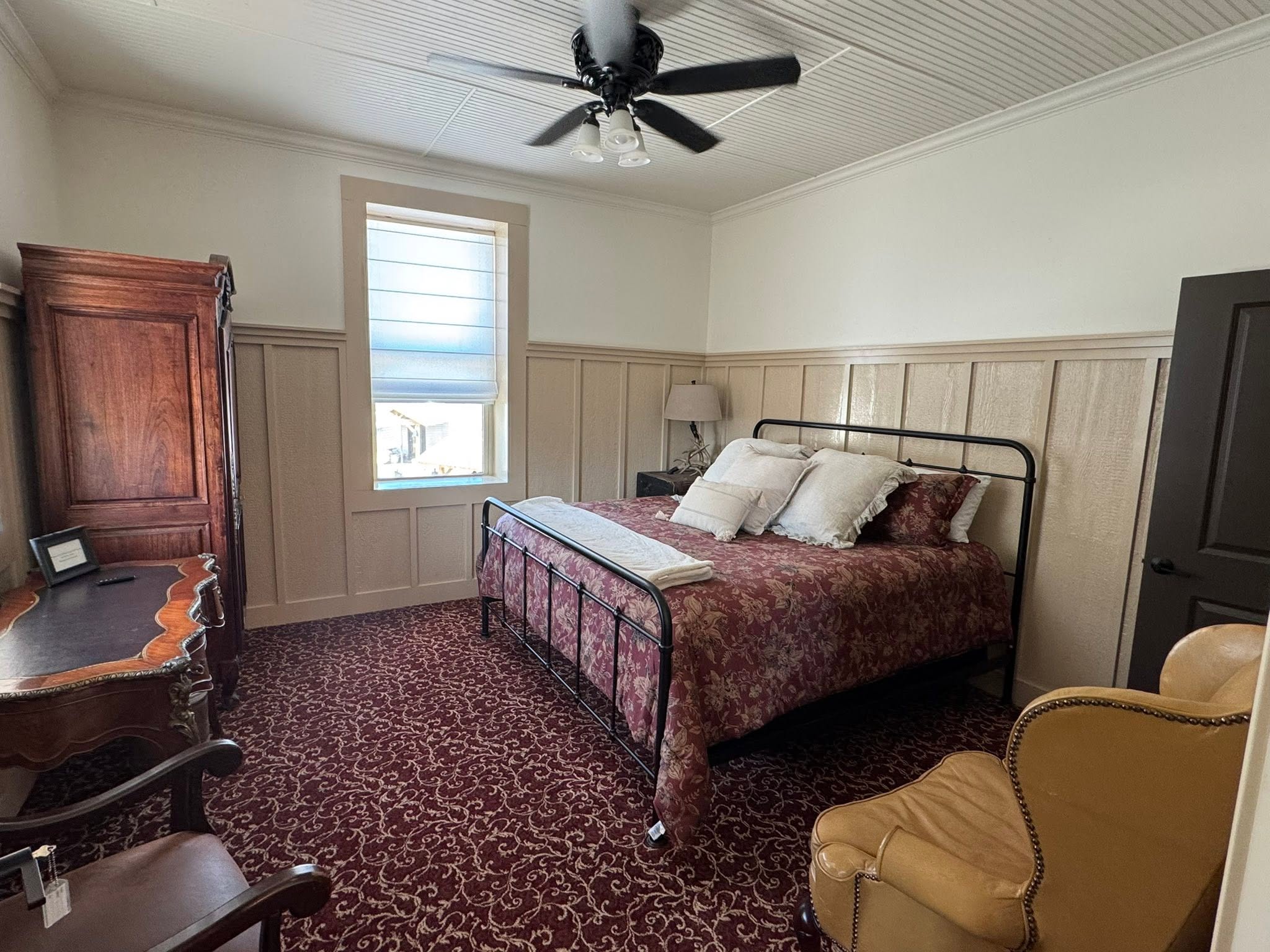 Vintage styled bedroom with red patterned carpet at GMTV Garage