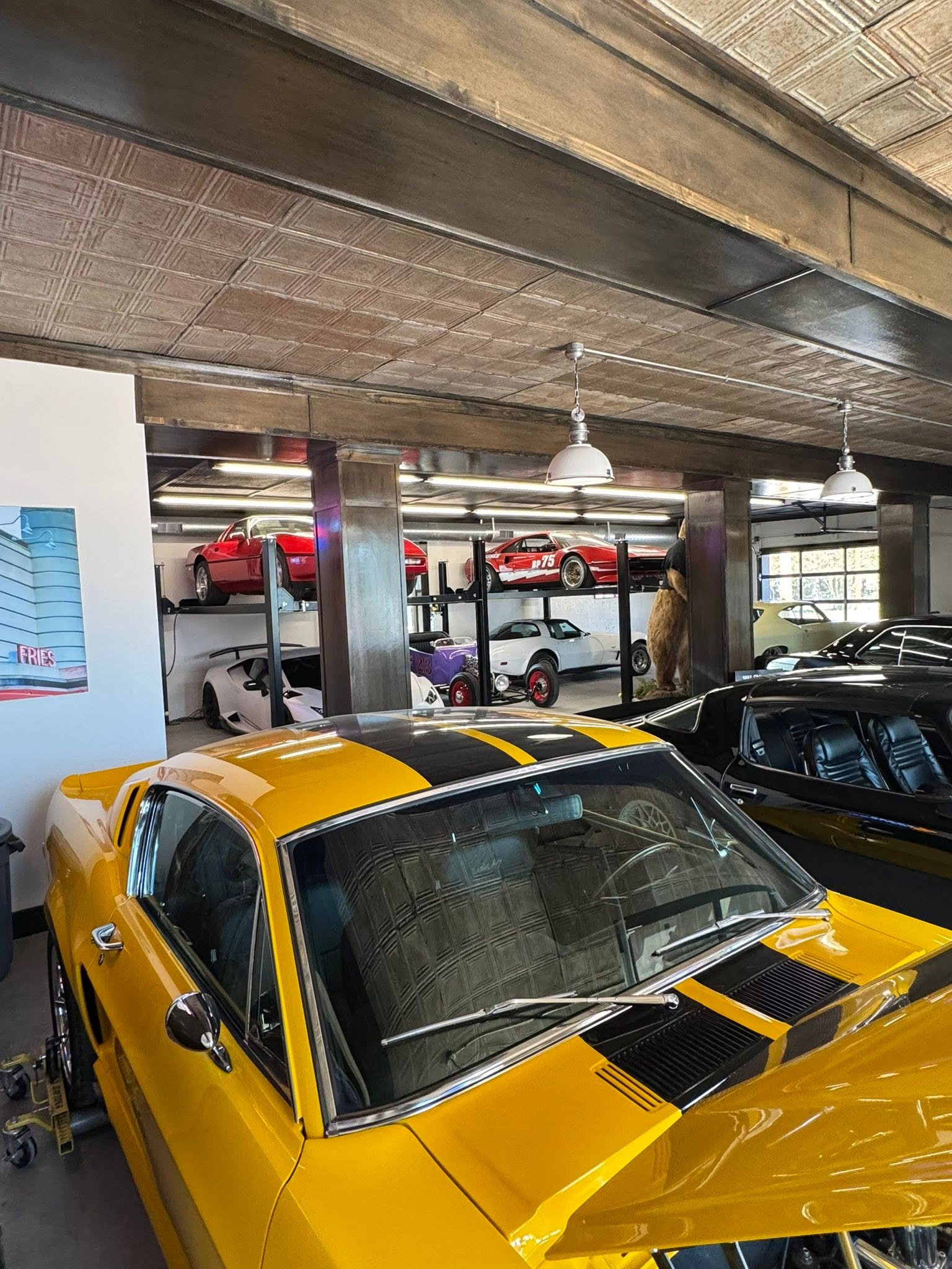 Yellow Ford Mustang with black stripes parked inside GMTV Garage