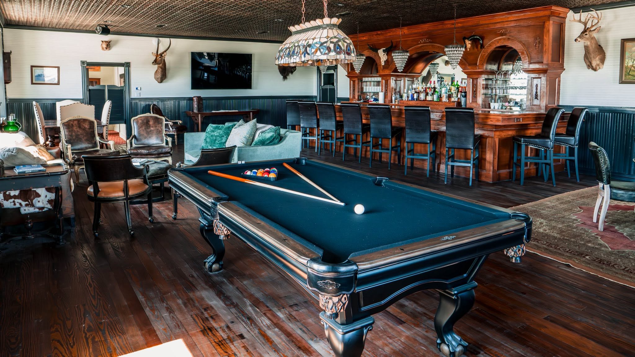 Pool table, saloon bar, and trophy mounts inside GMTV Garage