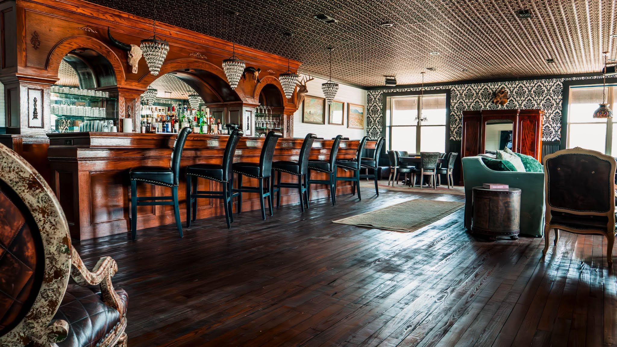 Carved wood saloon and green leather lounge inside GMTV Garage